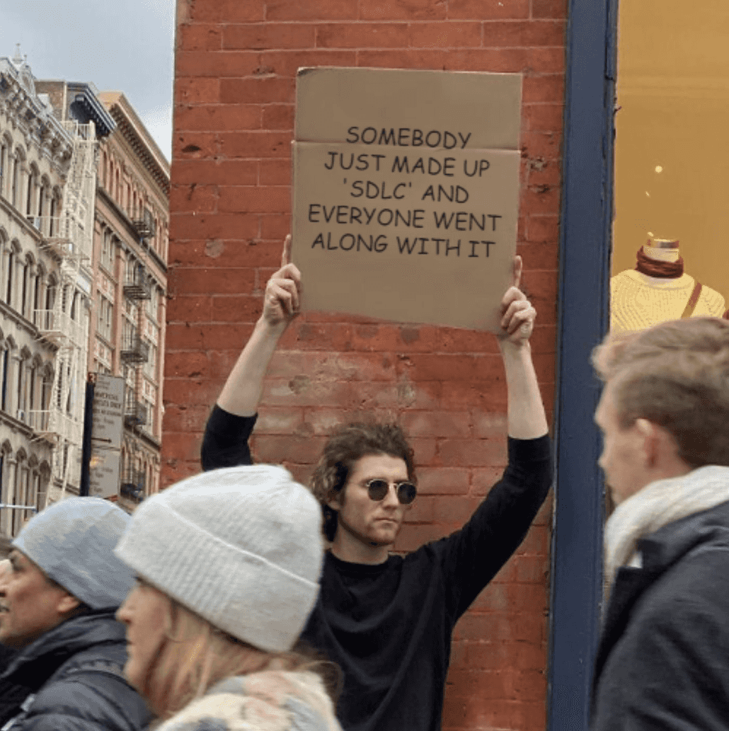 Man protesting with sign: Somebody just made up SDLC and everyone went along with it.